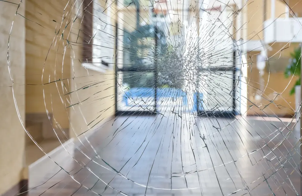 Security window film holding shattered glass together