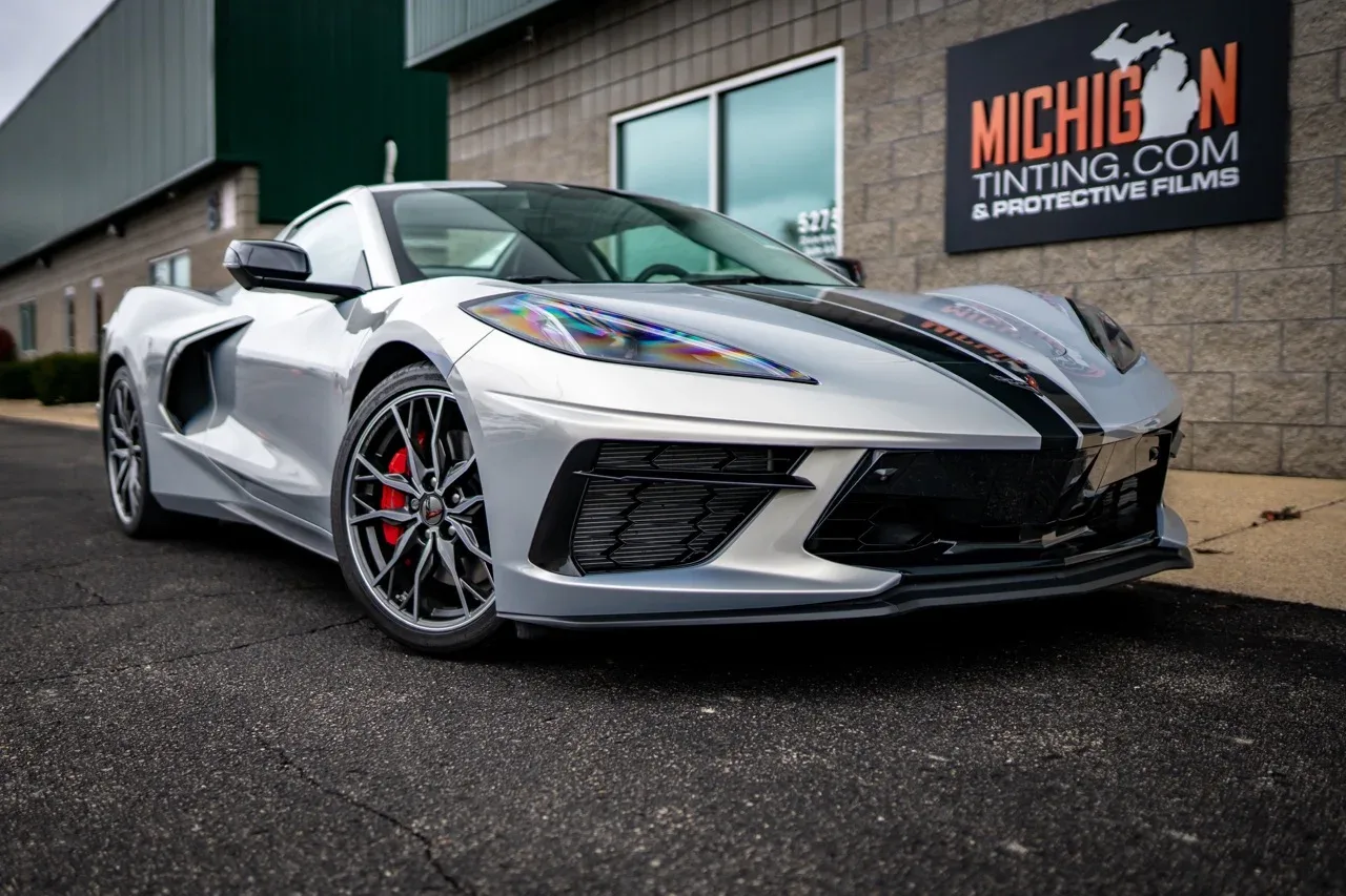 White Corvette C8 in front of the Michigan Tinting sign