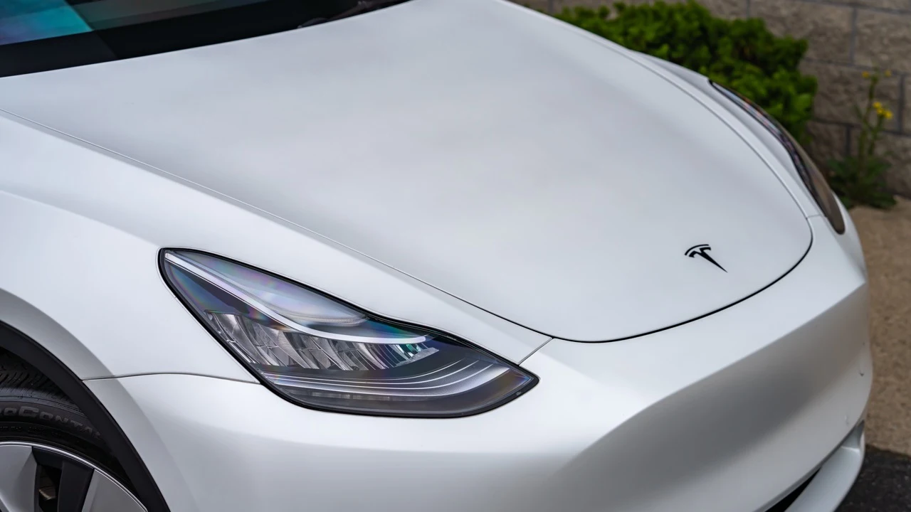 Headlight and front detail on a silver Tesla
