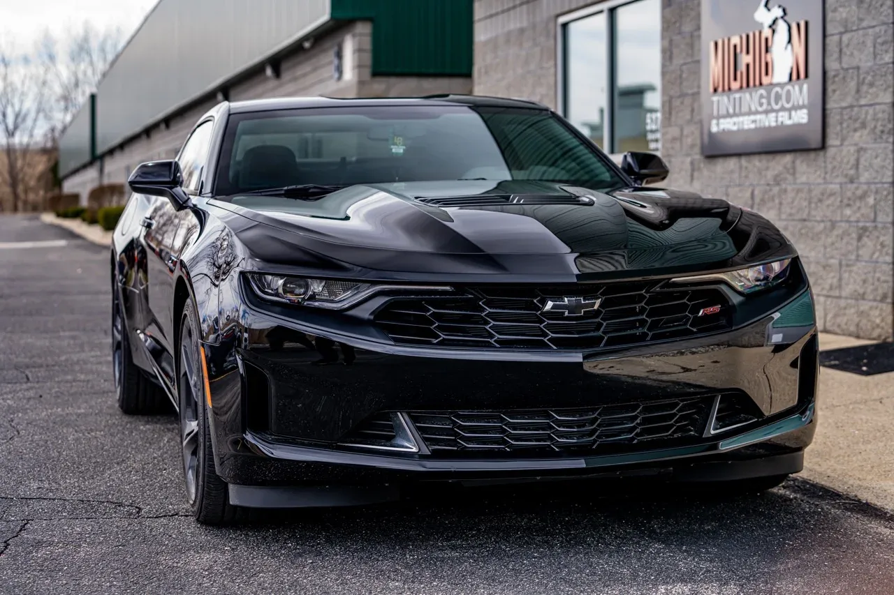 Black Chevrolet Camaro under a stormy sky