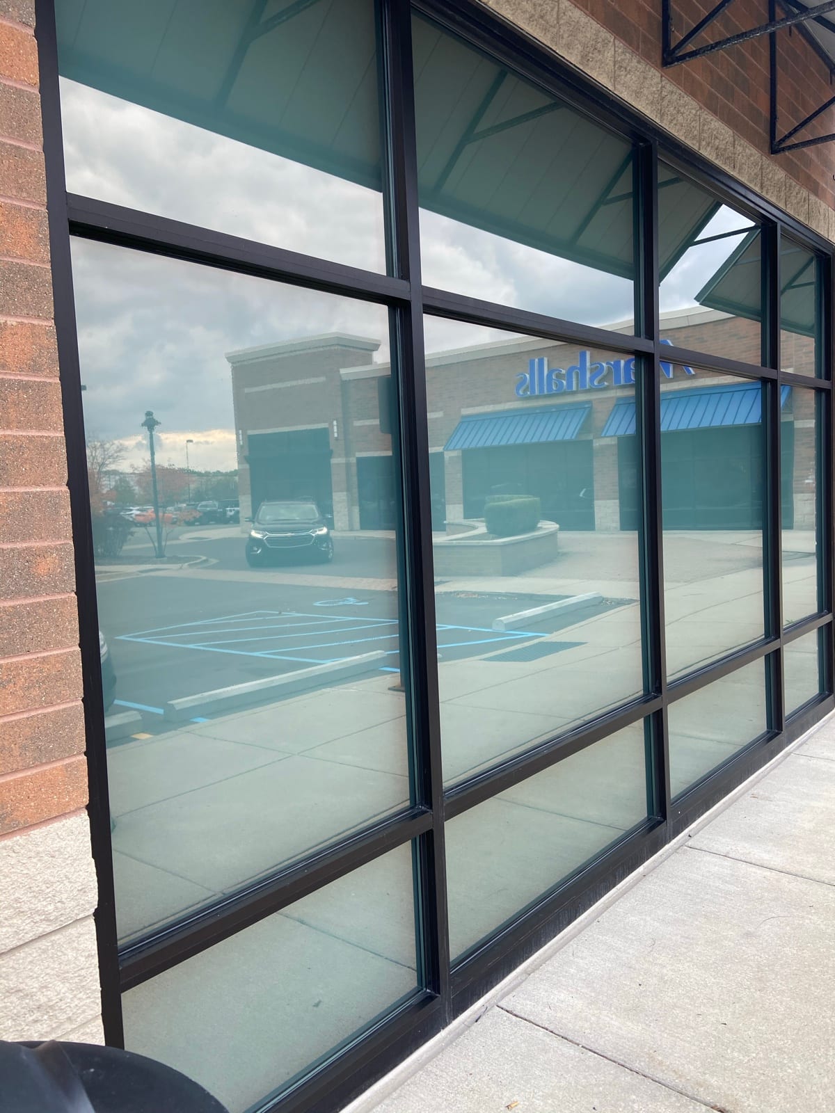 Storefront glass with reflective heat-control film