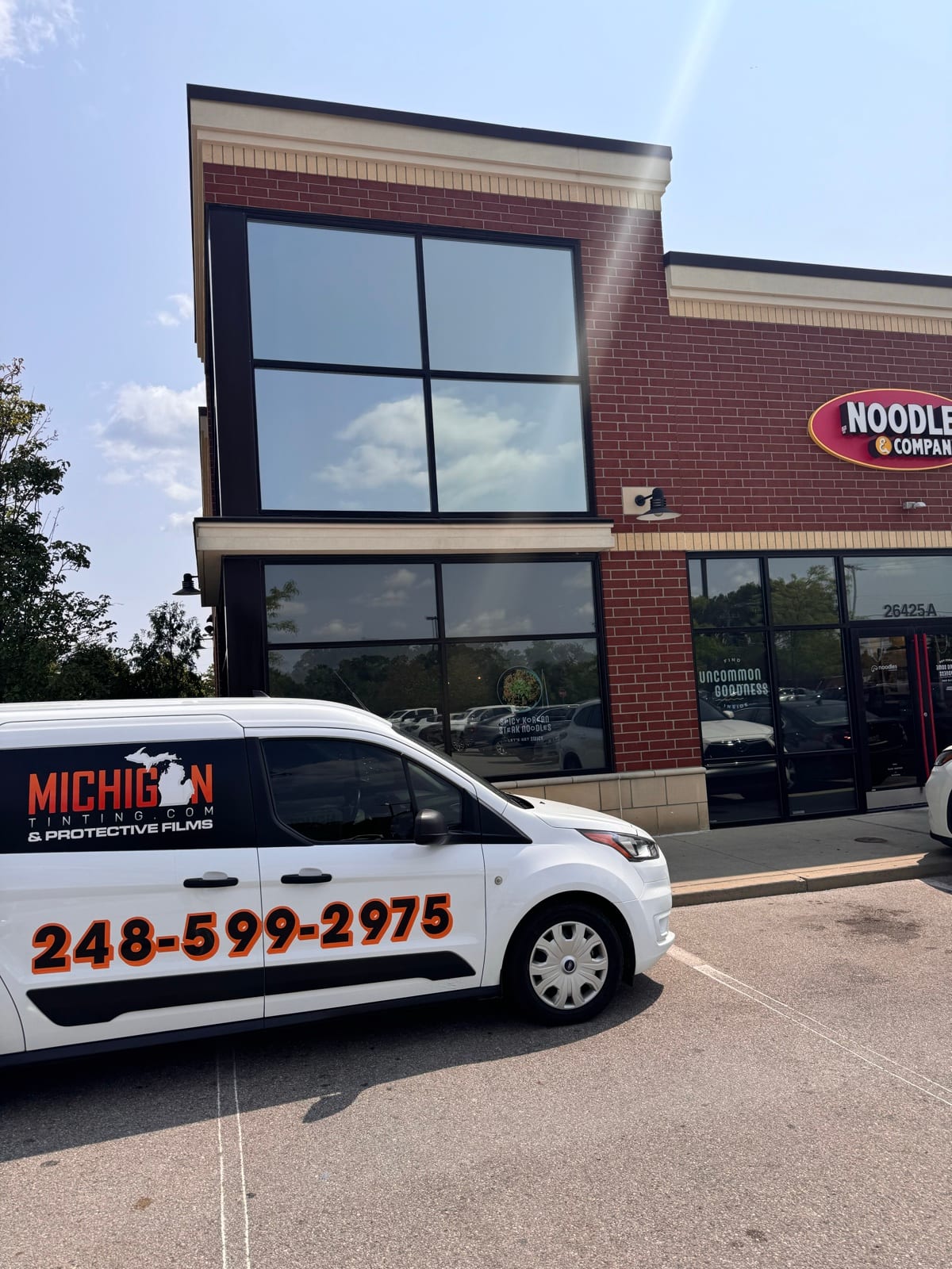 Michigan Tinting van outside a freshly tinted storefront